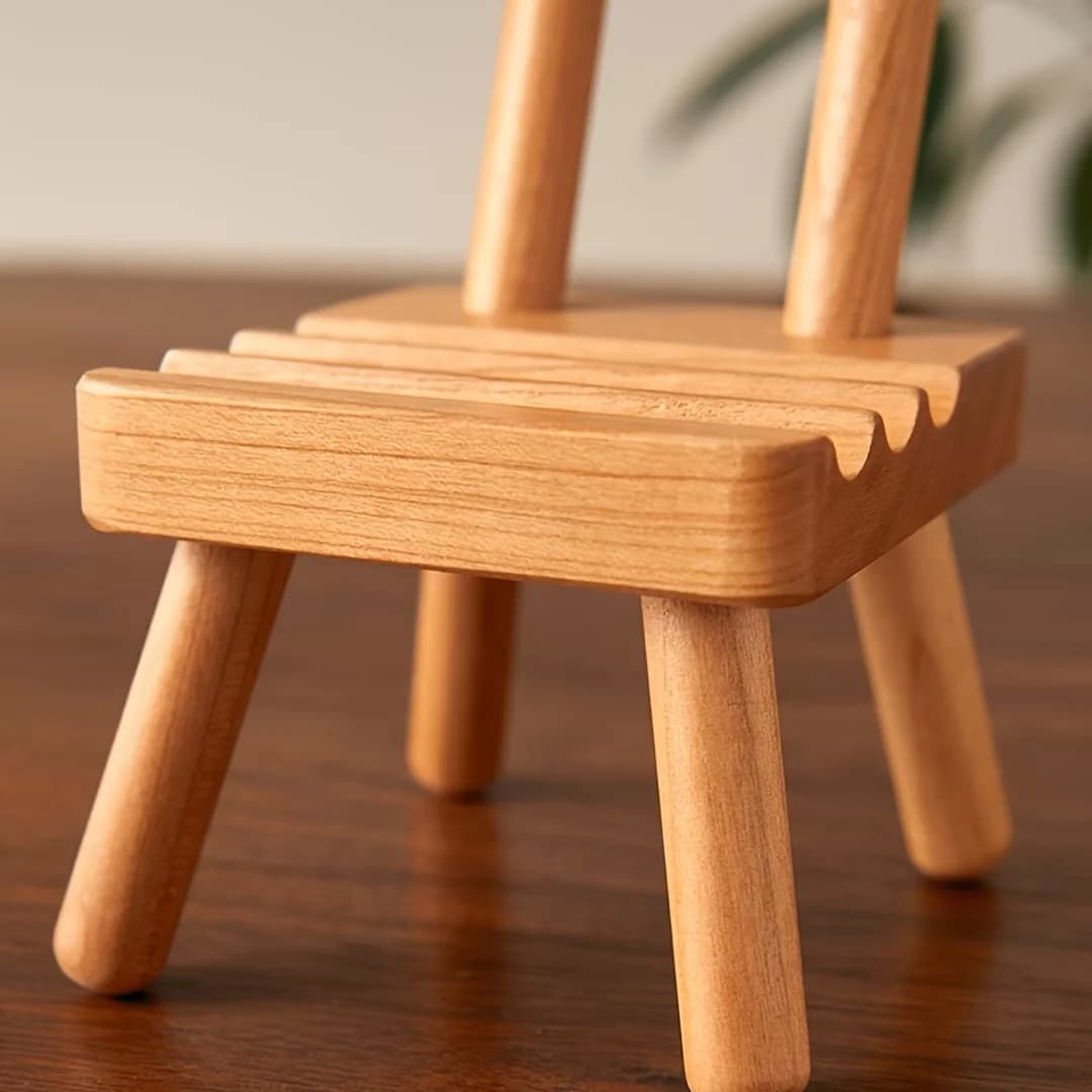 A chair-shaped mobile phone stand with three slots for stable support, suitable for large, medium and small-sized mobile phones