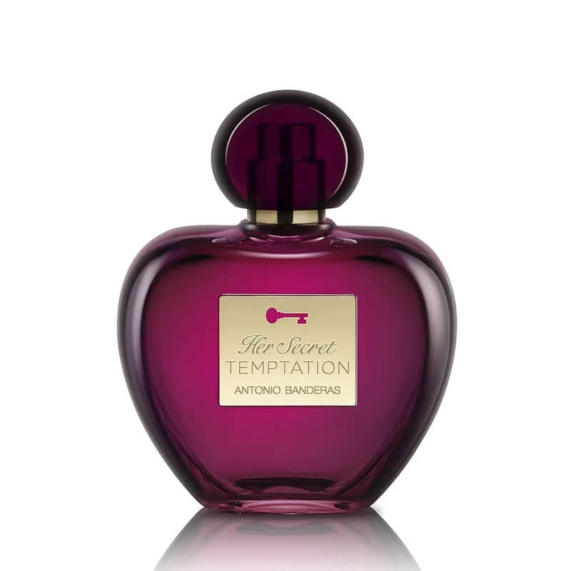 Pink heart-shaped perfume bottle with black cap next to purple box.